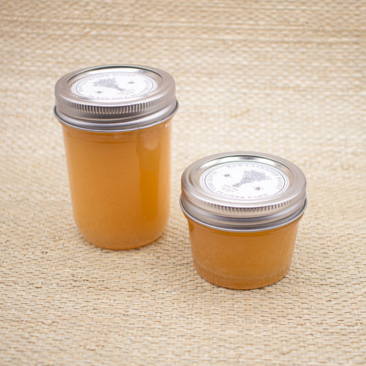 Lavender honey glass jars with silver mason jar styled screw cap lids and a Slate Hill Flower Farm logo with a lavender flower bundle graphic.